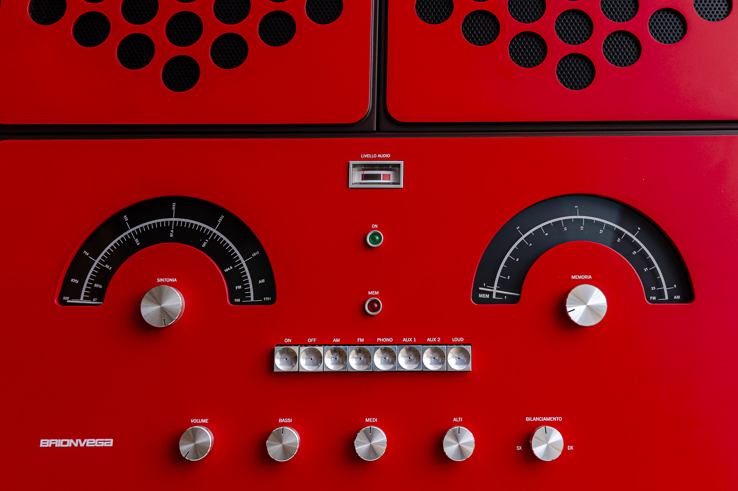 A detail shot of the handcrafted Italian wood console on the Brionvega Radiofonografo RR226 in a red finish, highlighting the iconic anthropomorphic design of the control dials and tactile analogue switches.