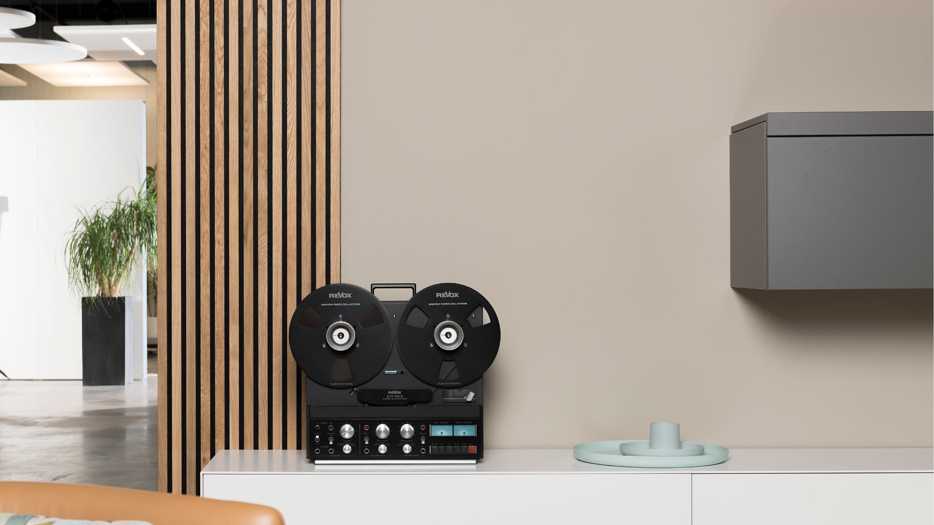 A front-profile view of the Revox B77 MK III reel-to-reel tape deck, showcasing its legendary industrial design, integrated carrying handle, and the precision-engineered aluminium reels.