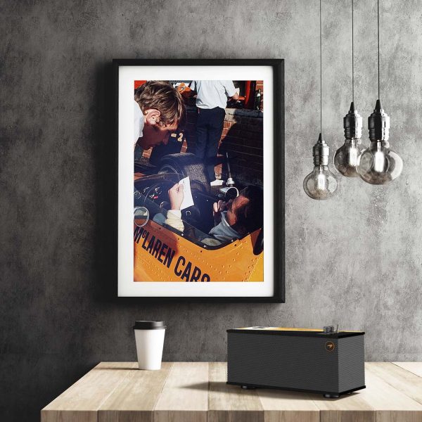 Klipsch The One McLaren Edition placed on a coffee table with a wall-hanging picture in the background