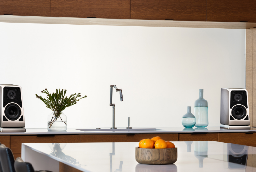 Wilson Audio bookshelf speakers styled within a modern luxury kitchen featuring minimalist cabinetry and contemporary décor.